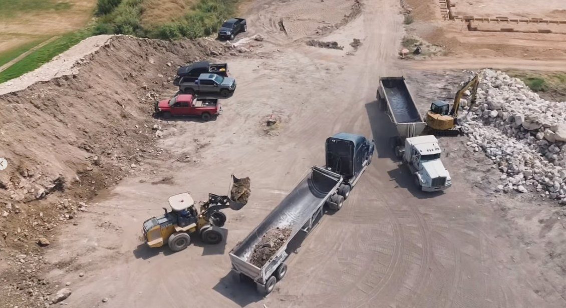 Aerial view of a wheel loader loading an end dump at a Houston-area material pit