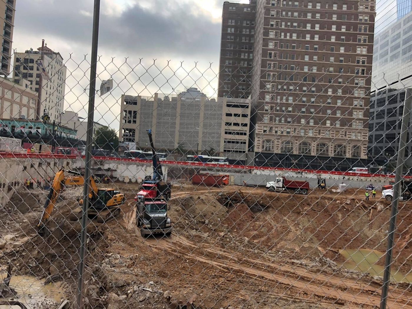 Excavator and dump trucks performing site excavation and dirt haul-off in Greater Houston